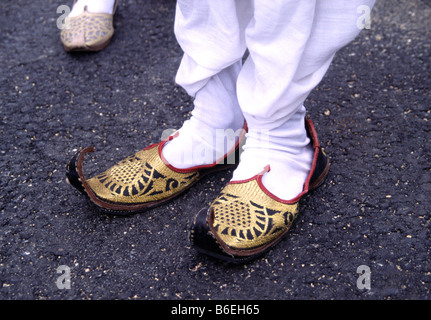 Auf der Suche nach unten auf Aladdins Hausschuhe zwei Füße beschuht in Golden bestickte Schuhe mit verwies Krause Zehen Oxford England 2005 Stockfoto