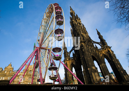 Weihnachten Schausteller Riesenrad, und gotischen Turm Kirche Architektur; Weihnachten Veranstaltungen und Attraktionen in die Princess Street, Edinburgh, Schottland, Großbritannien Stockfoto