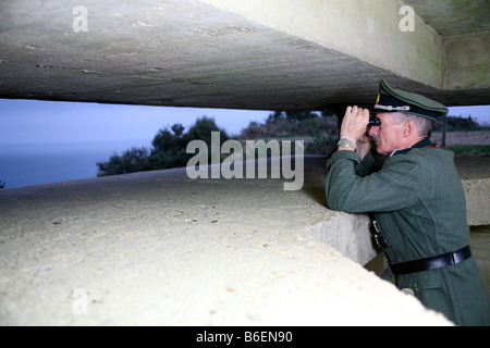 Ein Schauspieler verkleidet als ein deutscher Offizier, Blick über den Ärmelkanal von einem deutschen D-Day-Bunker in der Normandie Frankreich Stockfoto