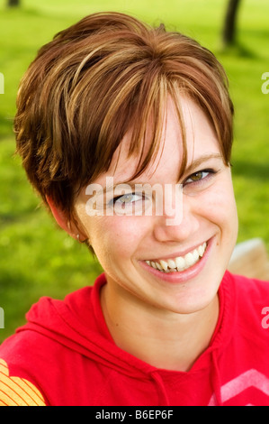 Glückliche junge Frau trägt einen roten Kapuzenpullover Stockfoto