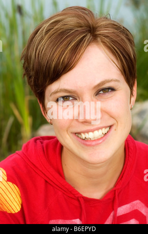 Glückliche junge Frau trägt einen roten Kapuzenpullover Stockfoto