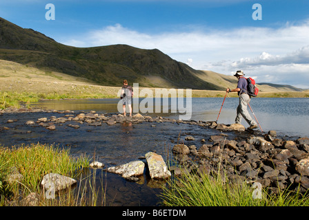 Wanderer, Trekker, die Überquerung eines Flusses, Saylyugem Berge, Tschuja-Steppe, Republik Altai, Sibirien, Russland, Asien Stockfoto