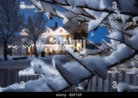 Ein malerisches altes Pionier Inn gesehen durch verschneite Bäume zur Weihnachtszeit im Pioneer Village State Park in Salt Lake City Utah USA Stockfoto