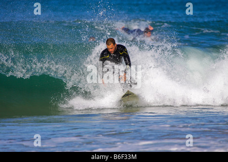 Surfer tilgt am Strand von Praia Grande Sintra Portugal Stockfoto