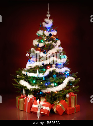 Leuchtender Weihnachtsbaum mit Geschenken unter ihm Stockfoto