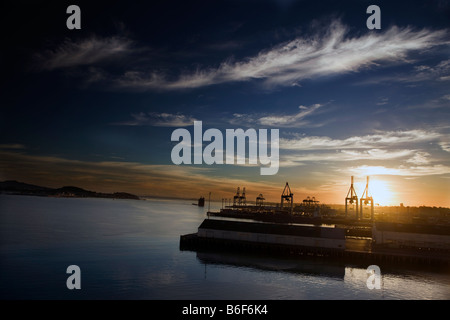 Die Sonne geht über Waitemata Harbour und Aucklands Versand Port, Auckland, Neuseeland Stockfoto