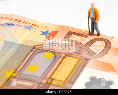 Senioren-Abbildung zu Fuß über einen 50 Euro-Banknote, als Symbol für Ruhestand Stockfoto