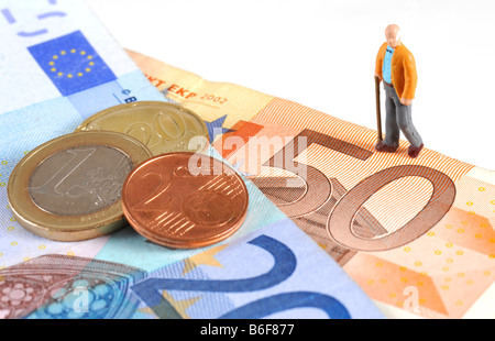 Senioren-Figur, die zu Fuß über eine Bank Euro-Banknoten und-Münzen, als Symbol für Ruhestand Stockfoto