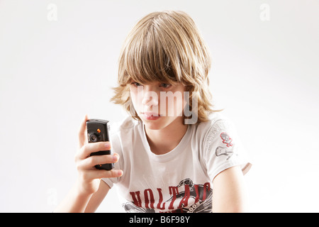 12 jähriger Junge spielt mit seinem Handy Stockfoto