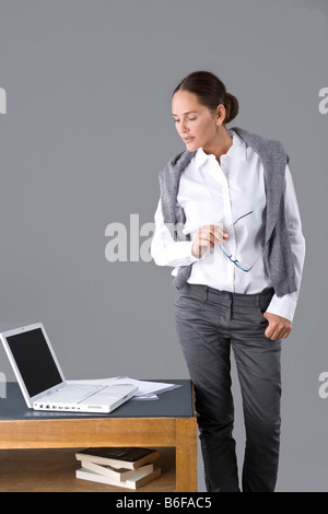Junge Frau stand vor ihrem Schreibtisch Stockfoto