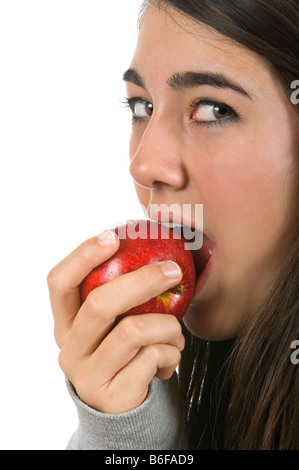 Vertikale Nahaufnahme Portrait eines attraktiven jungen Teenager Mädchen essen einen saftigen roten Braeburn Apfel vor einem weißen Hintergrund Stockfoto