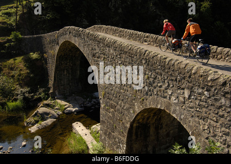 Radfahrer auf einer alten römischen Brücke in der Nähe von Lamastre, Ardèche, Rhônes-Alpes, Frankreich, Europa Stockfoto