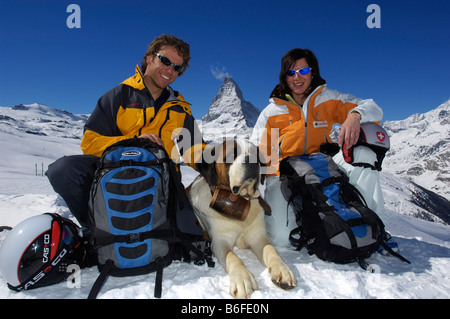 Skifahrer und ein St. Bernhard Hund trägt ein Fass Rum, Berg Matterhorn, Zermatt, Wallis oder Wallis, Schweiz, Europa Stockfoto