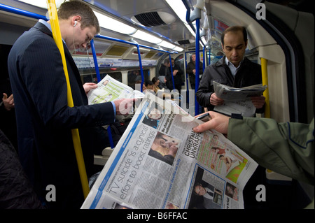 Pendler auf u-Bahn Zug lesen Zeitungen London Vereinigtes Königreich Stockfoto