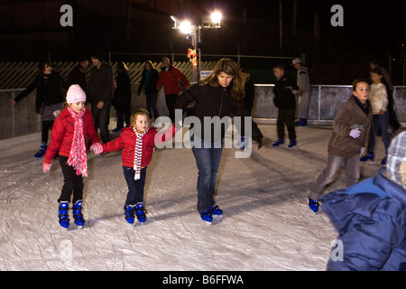 UK Cheshire Chester Zoo Frost Fair König Familie Mutter und Kinder auf Eisbahn Schlittschuh laufen Stockfoto