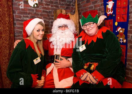 UK Cheshire Chester Zoo Frost Fair Weihnachtsmann posiert mit Elfen, Sarah und Emily Stockfoto