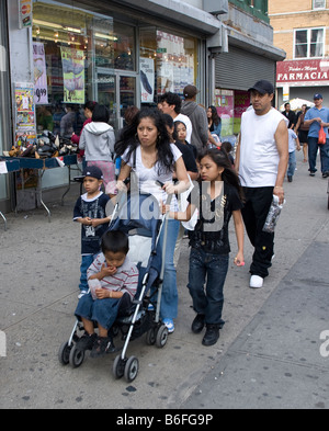 Hispanic Frau mit drei Kindern geht auf der 5th Avenue die Haupteinkaufsstraße in Sunset Park Brooklyn New York Stockfoto