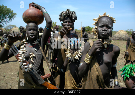 Wilde Frauen tragen Halsketten gemacht von Muscheln mit einer Maschinenpistole Kalaschnikow, vom Mursi Stamm, Jinka, Äthiopien, Afrika Stockfoto