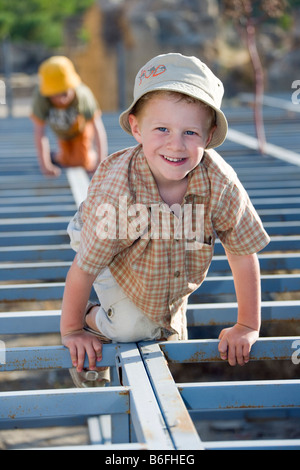 Zwei jungen Klettern auf ein langes Stahlrohr Rahmen Stockfoto