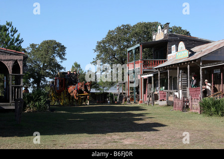 Zwei Cowboys, die einer alten Westernstadt Butterfield Overland Stage Coach durchfahren Stockfoto