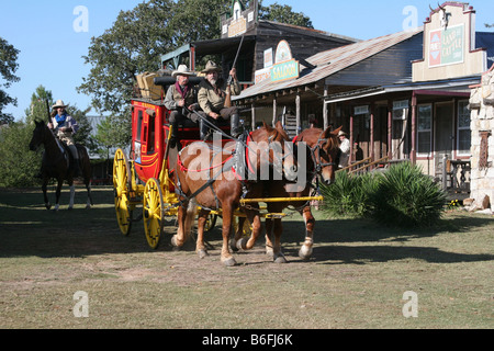 Zwei Cowboys, die einer alten Westernstadt Butterfield Overland Stage Coach durchfahren Stockfoto