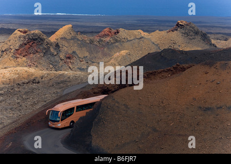 Reisen mit dem Bus Guagua, durch die Montanas del Fuego Berge des Nationalparks Timanfaya Lanzarote, Kanarische Isla Stockfoto