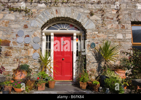 Aufwendige roten Eingangstür in einem Steingebäude, Clifden, Connemara, Irland Stockfoto