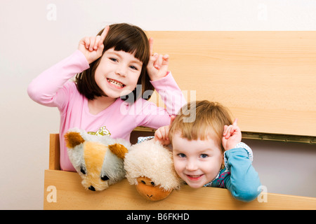 Zwei Schwestern, 6 und 3 Jahre alt, mit Eselsohren, Brünette und Blonde, drinnen Stockfoto