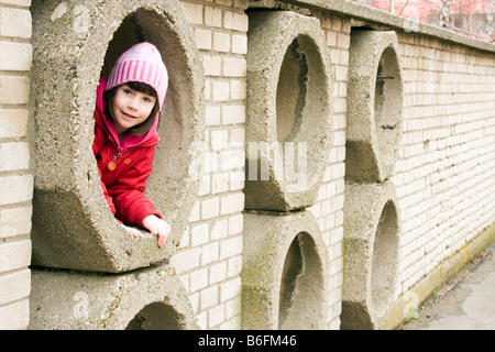 Kleines Mädchen, 6 Jahre, in einer hidey-hole Stockfoto