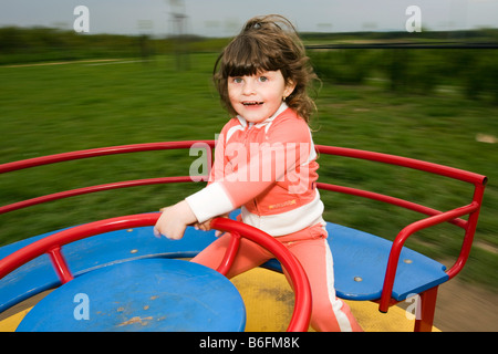Kleines Mädchen, 3 Jahre alt, am Karussell Stockfoto