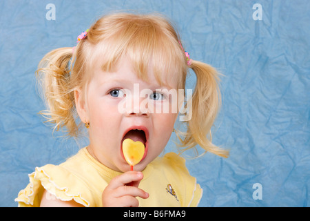 Blonde Mädchen, 2 Jahre, mit lollipop Stockfoto