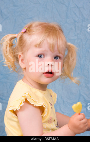 Blonde Mädchen, 2 Jahre, mit lollipop Stockfoto