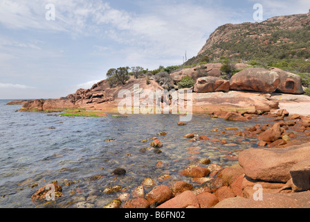 Roter Granit Felsformationen am kleinen kiesigen Strand, Ostküste Freycinet Peninsula, Tasmanien, Australien Stockfoto