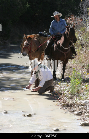 Goldwaschen in einem texanischen Fluss Anspruch Digger auf dem Pferderücken Stockfoto