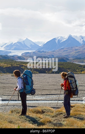 Zwei junge Frauen, Rucksacktouristen, Wanderer genießen die Aussicht auf Donjek Gletscher, Big Horn Creek, St. Elias Gebirge, Donjek Route, Kl Stockfoto
