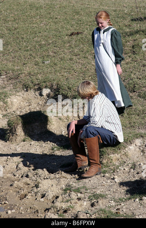 Ein kleiner Junge und ein Mädchen am Rande eines Teiches zu sprechen Stockfoto