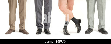 Vier Unternehmer stehen in einer Zeile ohne Hosen, Detail der Beine Stockfoto