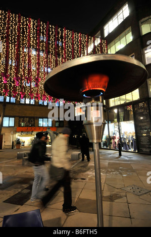 Londoner West End an Weihnachten mal Outdoor-Gas-Heizung neben Tabellen für Essen aus ähnlich wie so genannte Garten Patio-Heizungen Stockfoto