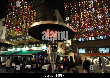 Calor Gasheizung an Tischen im Freien Essen ähnlich wie die sogenannten Garten Terrassenheizungen London West End Abendblick Weihnachtszeit England Großbritannien Stockfoto