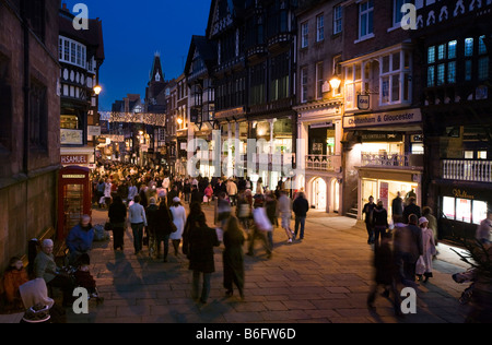 UK Cheshire Chester Eastgate Street Weihnachtsbeleuchtung über Shopper in der Abenddämmerung Stockfoto