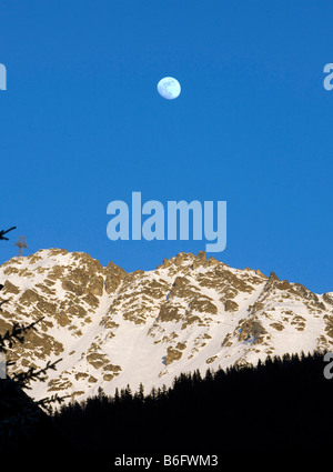 Der Mond in der Abenddämmerung im schweizerischen alpinen Ferienort Verbier Stockfoto