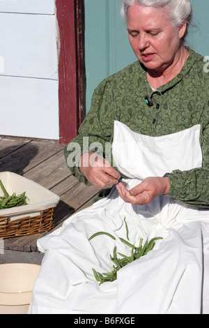 Eine Großmutter Figur einrasten Bohnen auf ihrem Bauernhof Veranda im Land Stockfoto