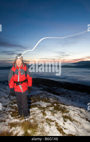 Ein Walker auf Wansfell Hecht in Lake District Großbritannien mit Tal Nebel unten Stockfoto