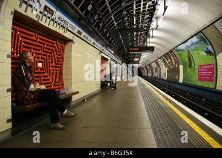 Mädchen junge Frau sitzend warten in der tube London unterirdische Plattform Stockfoto