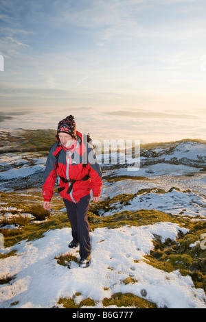 Ein Walker auf Wansfell Hecht in Lake District Großbritannien mit Tal Nebel unten Stockfoto