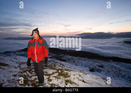 Ein Walker auf Wansfell Hecht in Lake District Großbritannien mit Tal Nebel unten Stockfoto