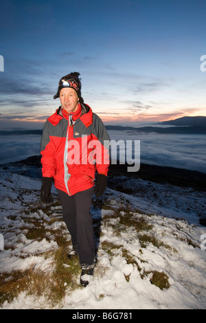 Ein Walker auf Wansfell Hecht in Lake District Großbritannien mit Tal Nebel unten Stockfoto