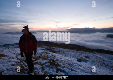 Ein Walker auf Wansfell Hecht in Lake District Großbritannien mit Tal Nebel unten Stockfoto