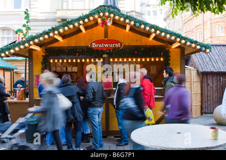 Kunden-Warteschlange für Bratwurst in einem Stall auf Manchester Continental Markt Stockfoto