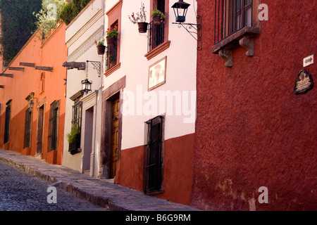 Bunte Gebäude entlang eine gepflasterte Straße in San Miguel de Allende, Mexiko Stockfoto